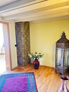 a living room with a fireplace and a vase of flowers at Gästehaus Herzog in Uhldingen-Mühlhofen