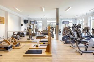 einen Fitnessraum mit Laufbändern und Crosstrainern in der Unterkunft nordica Hotel Friesenhof in Büsum