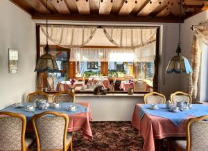 a restaurant with two tables and chairs and a mirror at Gästehaus Herzog am Bodensee in Uhldingen-Mühlhofen +38 photos