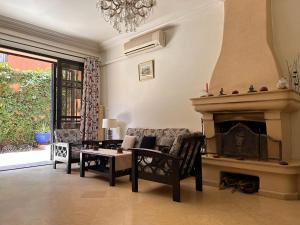 Villa Targa Piscine 10 minutes du centre في مراكش: غرفة معيشة مع أريكة ومدفأة