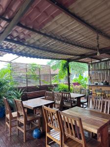 een patio met houten tafels en stoelen bij Coral azul Noronha in Fernando de Noronha