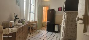 - une cuisine avec un réfrigérateur noir dans la chambre dans l'établissement Le St Amour Élégant 2 chambres *Wifi/Super Centre*, à Besançon