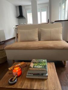a living room with a couch and a table with a book at Joya en el corazón de Ribeira in Ribeira