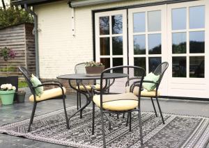einen Terrassentisch und Stühle auf einer Terrasse in der Unterkunft Guesthouse 't Oeyenbos in Knegsel