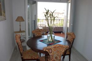 una mesa de comedor con sillas y un jarrón. en Apartamentos Vado - Cuesta de Alhacaba en Granada