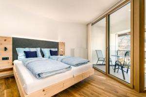 a bedroom with a large bed with blue pillows at Untermoarhof Albeins in Bressanone