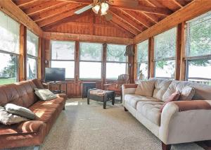 sala de estar con sofás y ventilador de techo. en Cottage on Lake Ontario en Waterport