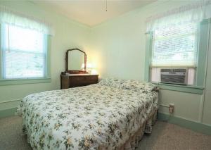 1 dormitorio con cama, espejo y ventanas en Cottage on Lake Ontario en Waterport