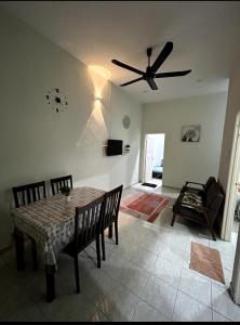 a dining room with a table and a ceiling fan at WK HOMESTAY PASIR MAS in Pasir Mas