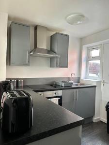 a kitchen with stainless steel appliances and a counter top at Liverpool townhouse sleeps 6 with free on street parking in Liverpool
