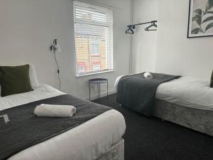 a hotel room with two beds and a window at Liverpool townhouse sleeps 6 with free on street parking in Liverpool