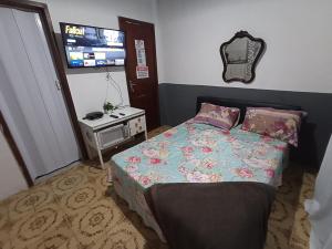 a bedroom with a bed and a tv on the wall at Refugio Piratininga 201 in Niterói