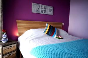拉高萊特的住宿－勒莫納齊特別墅，卧室配有白色床和紫色墙壁