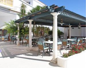 a patio with tables and chairs under a pavilion at Hotel Al Sur De Chipiona by YouRoom in Chipiona