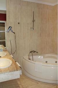 a bathroom with a tub and a sink at Hotel Al Sur De Chipiona by YouRoom in Chipiona