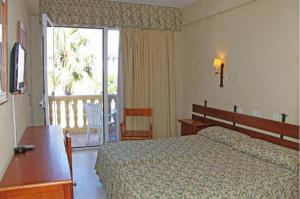a hotel room with a bed and a balcony at Hotel Al Sur De Chipiona by YouRoom in Chipiona
