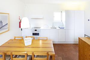 a kitchen with a wooden table and chairs at Convento das Bernardas by MY CHOICE in Tavira