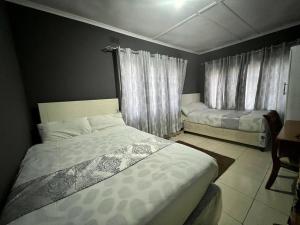 1 dormitorio con 2 camas y ventana en Golden bamboo, en Masvingo