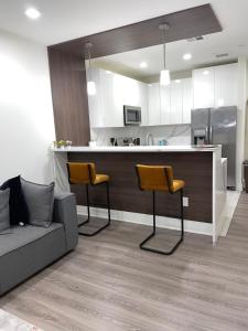 a kitchen with a bar with two chairs and a couch at 45 William st Newark NJ in Newark