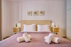 a bedroom with a bed with two towels on it at Paradosiakon Apartment Corfu Town in Corfu