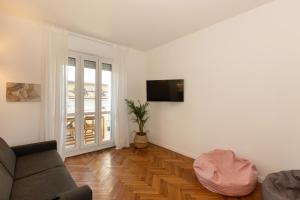 un soggiorno con divano e TV a schermo piatto di Gaffurio Apartments a Milano