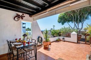 a patio with a table and chairs and a balcony at Casa La Rosa Del Mar in Costa Teguise