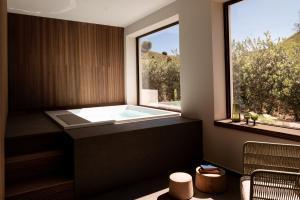 a bathroom with a bath tub with a window at Luna Minoica Suites and Apartments in Montallegro