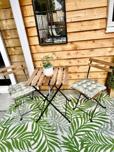 2 Stühle und ein Tisch auf einer Veranda mit einem Teppich in der Unterkunft The Mudeford Gem Accommdation in Christchurch