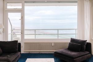 sala de estar con sofá y ventana grande en De Steltloper en Zandvoort