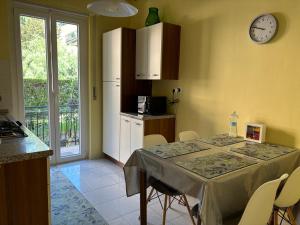 una cucina con tavolo e orologio sul muro di New apartment next to the sea a Bordighera
