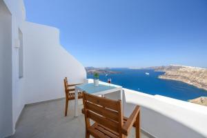 balcón con mesa y sillas y vistas al océano en Spectacular view Caldera St Μ en Megalokhori