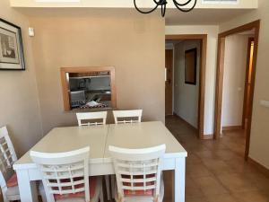 a dining room with a white table and chairs at Aquamarina - Serviden in Denia