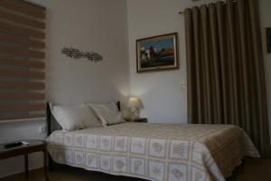 a bedroom with a bed and a picture on the wall at KOLLITAKI in Selínia
