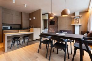 una cucina e una sala da pranzo con tavolo e sedie di Wachtler Dolomite Apartments a San Candido