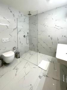 a white bathroom with a shower and a toilet at Štupartská 9 - Old Town Residence in Prague