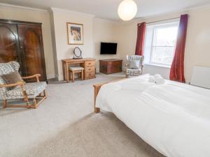 a bedroom with a bed and a desk and a tv at Jubilee House in Alnwick