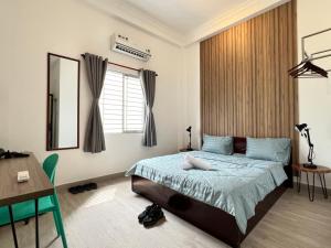 a bedroom with a bed and a table and a desk at Coco Homestay in Ho Chi Minh City