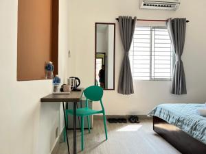 a bedroom with a desk and a green chair in front of a mirror at Coco Homestay in Ho Chi Minh City +39 photos