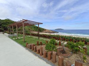 a garden with a wooden pavilion next to the beach at Refugio Piratininga 201 in Niterói