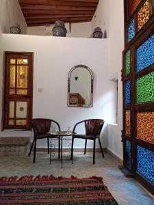 a room with a table and two chairs and a mirror at Dar Mchachti fes in Fez