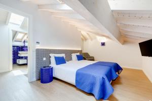 ein Schlafzimmer mit einem großen Bett mit einer blauen Decke in der Unterkunft Casinhas da Praia in Vila Praia de Âncora