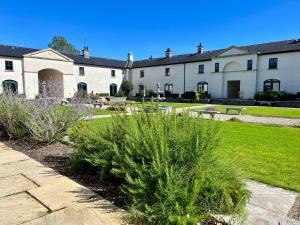 a large white building with plants in a yard at 3 Castle Hume Court Holiday House in Enniskillen