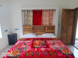 a bedroom with a large bed with a red blanket at Munnar Pavithra Riverview Homestay in Munnar