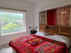 a bedroom with a large bed with a large window at Munnar Pavithra Riverview Homestay in Munnar