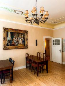 a dining room with a table and a painting on the wall at Pension Am Park in Berlin