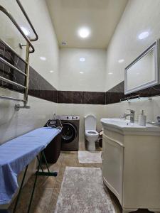 uma casa de banho com um lavatório e uma máquina de lavar roupa em Huvaydo Residence Apartment em Tashkent