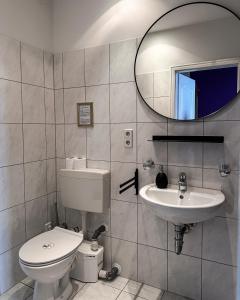 a bathroom with a toilet and a sink and a mirror at Pension Am Park in Berlin