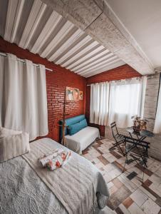um quarto com uma cama, um sofá e uma mesa em Apêzinho Vidigal - RJ no Rio de Janeiro