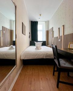 a bedroom with two beds and a mirror and a desk at Pension Am Park in Berlin