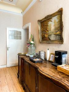 a wooden table in a room with a painting on the wall at Pension Am Park in Berlin +30 photos